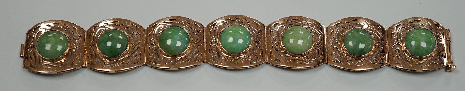 A continental 18k yellow metal and seven stone cabochon jade set bracelet, with pierced links, 18.5cm, gross weight 39.3 grams.